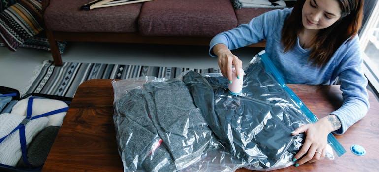 A woman following a NYC small apartment survival guide and vacuum packing