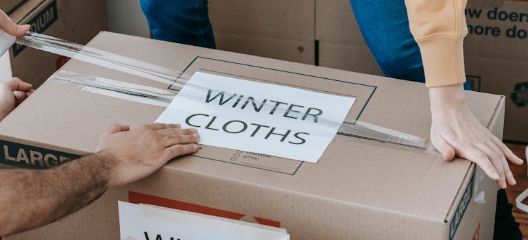 A couple sealing a moving box and having a winter move in the Bronx